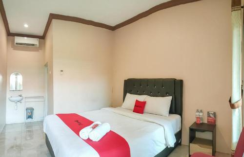 a bedroom with a bed with two towels on it at RedDoorz Syariah near Lippo Plaza Sidoarjo in Sidoarjo