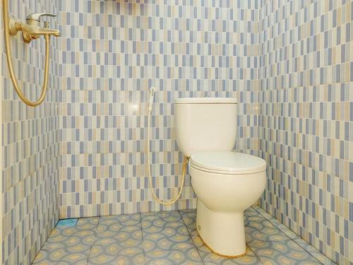 a bathroom with a toilet in a tiled wall at RedDoorz Syariah near Lippo Plaza Sidoarjo in Sidoarjo