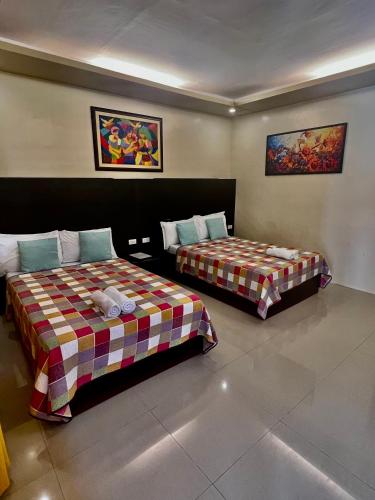 two beds in a hotel room with at Hotel Casa Teofista in Panglao