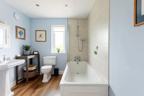 ein Badezimmer mit einer Badewanne, einem WC und einem Waschbecken in der Unterkunft Blackhill Farm Cottage in Perth