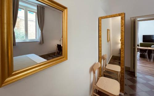a mirror hanging on a wall next to a room at Palazzo Pitagora in Taranto