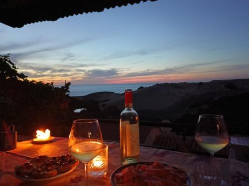 a table with two glasses and a bottle of wine at Casa vacanze Sardegna, Torre dei Corsari Costa Verde in Torre Dei Corsari