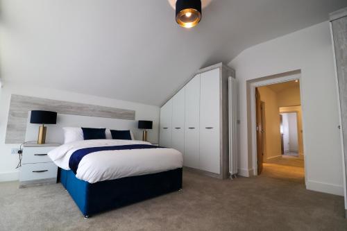 a bedroom with a large bed and white cabinets at Northumberland Luxury Stays - The Gavel in West Chevington