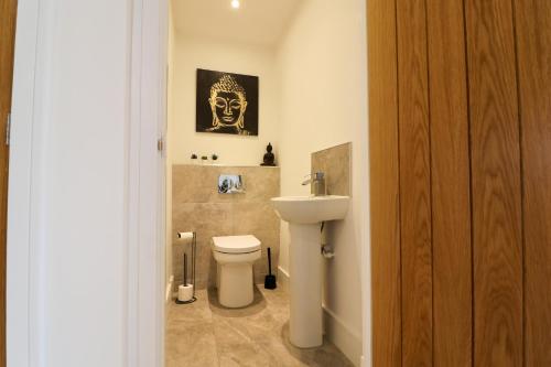 ein Badezimmer mit einer weißen Toilette und einem Waschbecken in der Unterkunft Northumberland Luxury Stays - The Gavel in West Chevington