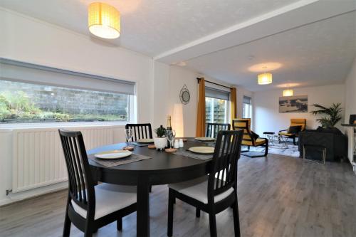 a dining room with a black table and chairs at Signature - Alder View in Cumbernauld