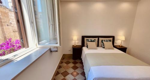 a bedroom with a bed and a window at Palazzo Pitagora in Taranto