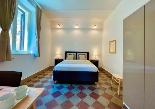 a bedroom with a bed and a table and a chair at Palazzo Pitagora in Taranto