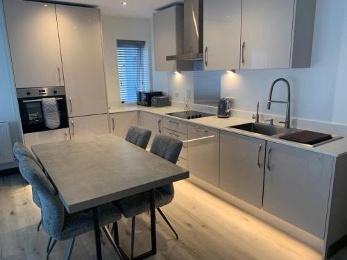 a kitchen with a table and chairs and a sink at Ackroyd House, Edinburgh Way in Harlow