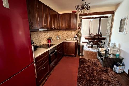 cocina con armarios de madera y nevera roja en Mountain View - Full Villa, en Polydrosos