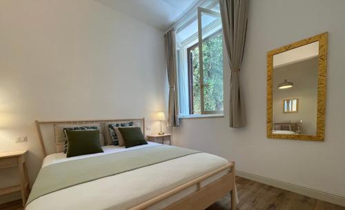 Schlafzimmer mit einem Bett mit einem Spiegel und einem Fenster in der Unterkunft Palazzo Pitagora in Taranto
