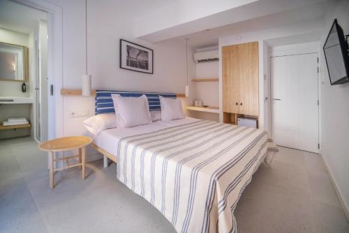 Un dormitorio con una cama grande y una mesa pequeña. en HOTEL BINI, en Porto Cristo