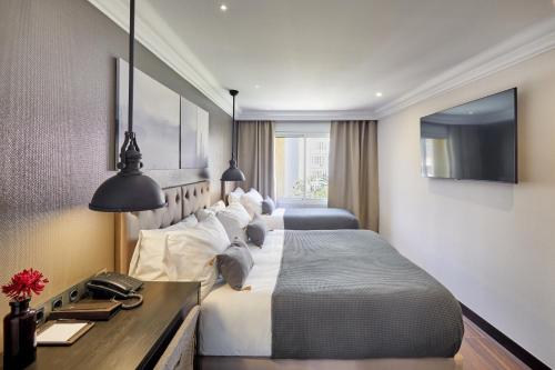 a hotel room with two beds and a television at Hotel Cortes Rambla in Barcelona
