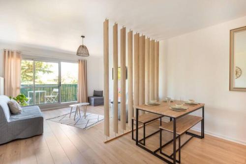 ein Wohnzimmer mit einem Tisch und einem Sofa in der Unterkunft Grand studio pro calme proche centre commodités in Talence