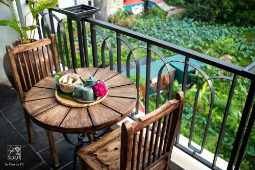 a wooden table with a plate of food on a balcony at Le Clos Du Fil in Ninh Binh