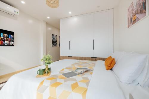 a bedroom with a large bed with yellow and white at Myrcella Urban Studio in Hanoi