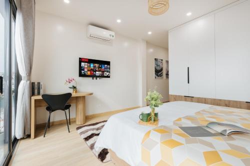 a bedroom with a bed and a desk at Myrcella Urban Studio in Hanoi