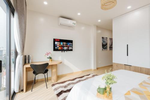 a bedroom with a desk and a table in a room at Myrcella Urban Studio in Hanoi