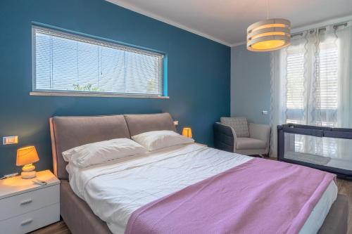 - une chambre avec un grand lit et un mur bleu dans l'établissement Casa Dolce con jacuzzi e piscina, à Brucoli