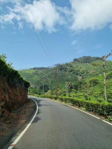 an empty road on the side of a hill at Camellia Heights 1&2 in Coonoor