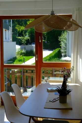 a dining room table with white chairs and a large window at Traumurlaub WestCoast Ammersee 7 Gehminuten zum See in Schondorf am Ammersee