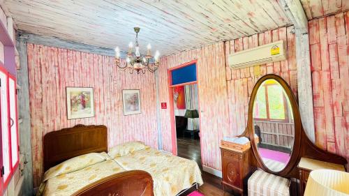 a bedroom with a bed and a mirror at Baan Ing Khao in Pak Chong