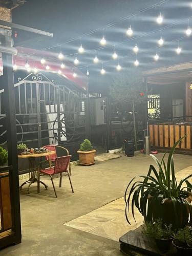 a patio with a table and chairs and lights at Golden Fleece Hotel in Ureki