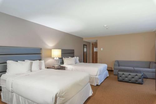 um quarto de hotel com duas camas e um sofá em DoubleTree by Hilton Bloomington Minneapolis South em Bloomington