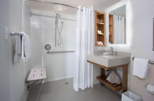 a white bathroom with a sink and a shower at New York Hilton Midtown in New York