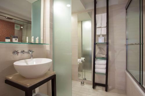 a bathroom with a sink and a glass shower at DoubleTree by Hilton San Juan in San Juan