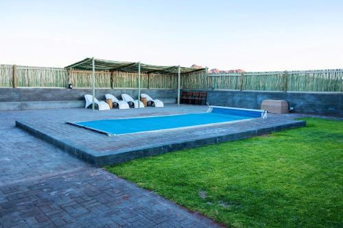 a swimming pool in the backyard of a house at At Kronenhof Campsites in Sesriem