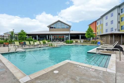 a large swimming pool in front of a building at Homewood Suites TechRidge Parmer @ I-35 in Austin