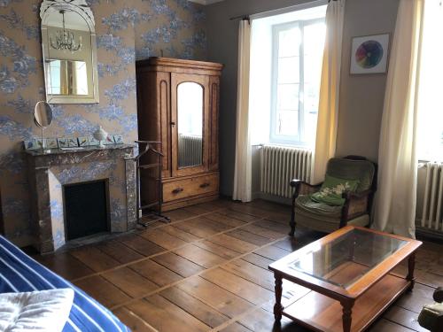 - un salon avec une cheminée et une table dans l'établissement Résidence étoile, à Saint-Yrieix-la-Perche
