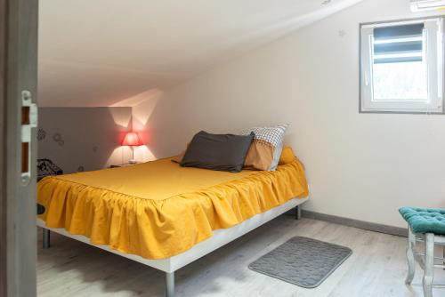 um quarto com uma cama com um cobertor amarelo em Villa Marie Carmen em Rivesaltes