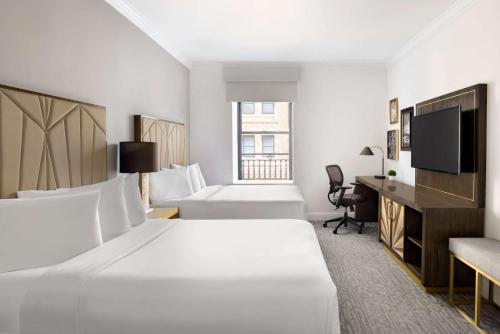 A bed or beds in a room at Martinique New York on Broadway, Curio Collection by Hilton