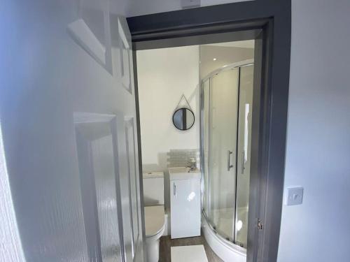 a bathroom with a large mirror and a sink at Silver Stag Properties, Ensuite Bedrooms w Kitchen in Swadlincote