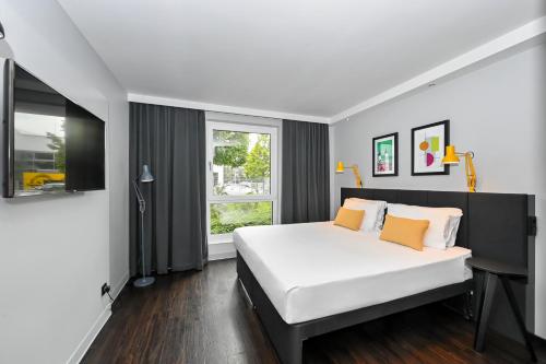 a bedroom with a large white bed and a window at Staycity Aparthotels Heidelberg in Heidelberg