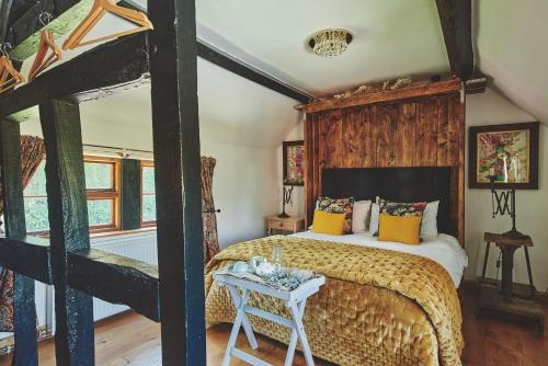 a bedroom with a large bed with a wooden wall at Powk Meadow Farmhouse in Leominster