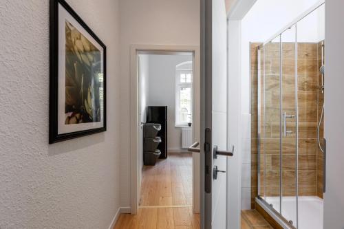 a hallway with a glass door leading to a bathroom at unique Malterstraße feel-good-home - Dresden in Dresden