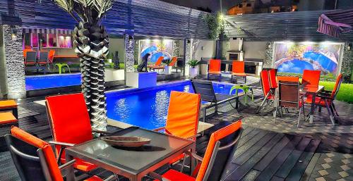 un restaurante con mesa y sillas y una piscina en Villa RICH, en Timisoara