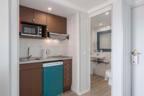 a small kitchen with a sink and a microwave at Dorisol Mimosa Studio Hotel in Funchal