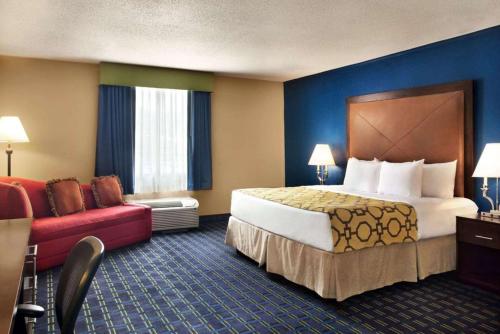 a hotel room with a large bed and a red couch at Express Inn and Suites in Little Rock