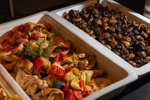 two trays of different types of food on a table at Family Hotel Pagus - All Inclusive in Pag
