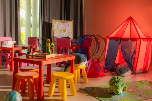 a room with colorful tables and chairs and a play area at Family Hotel Pagus - All Inclusive in Pag