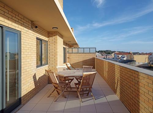 eine Terrasse mit einem Tisch und Stühlen auf dem Balkon in der Unterkunft Sunset Lounge CorgoMar in Lavra