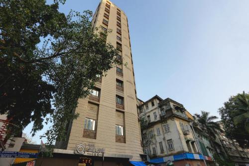 un grand bâtiment sur le côté d'une rue dans l'établissement Hotel Ozone Inn Colaba, à Mumbai
