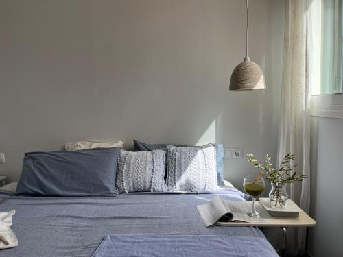 a bed with a blue comforter and a table with a book at Ático en el mar in Alcossebre
