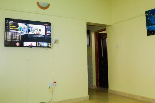 KAJIADOHOMES في Kajiado: غرفة فارغة مع تلفزيون على الحائط