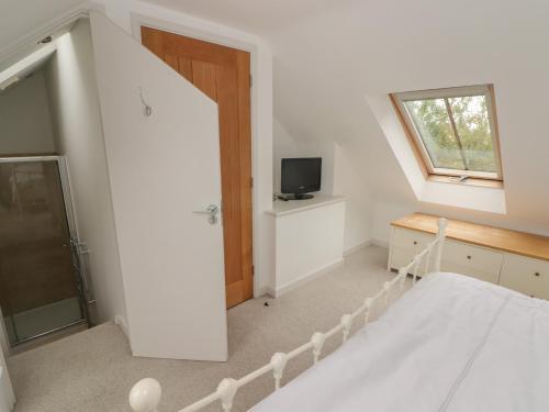 a white bedroom with a bed and a window at One Tree House in Dinas