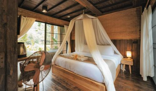 a bedroom with a hammock bed and a window at อุ่นไอมาง สะปัน in Ban Huai Ti