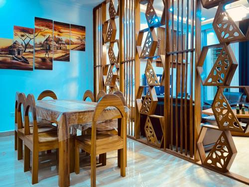 uma sala de jantar com uma mesa de madeira e cadeiras em BIZI HOMES, KABUGA 